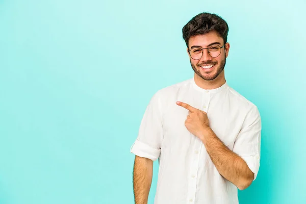Νεαρός Καυκάσιος Άνδρας Απομονωμένος Μπλε Φόντο Χαμογελώντας Και Δείχνοντας Στην — Φωτογραφία Αρχείου