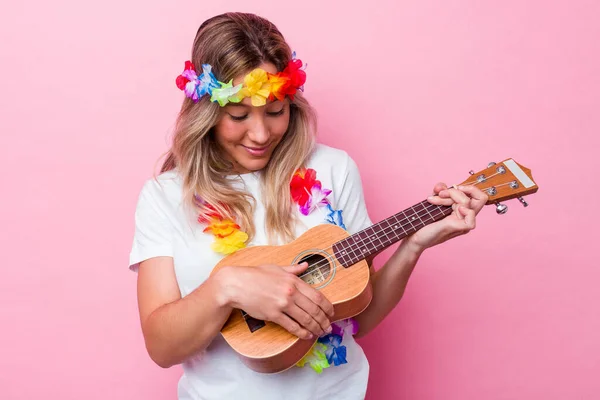 年轻的Hawaiian女人扮演一个被粉色背景隔离的Ukulele — 图库照片