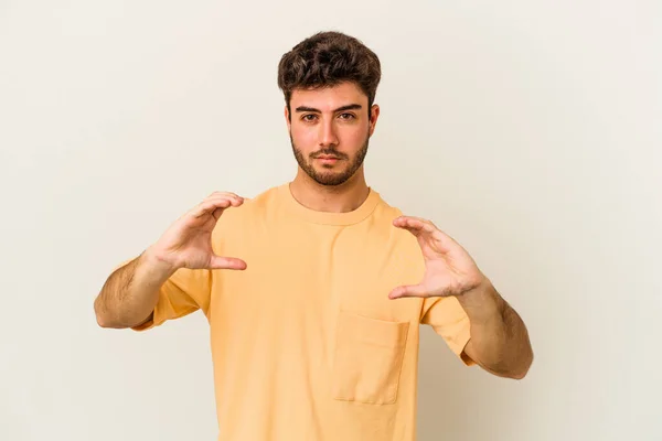 Jovem Caucasiano Isolado Fundo Branco Segurando Algo Com Palmas Das — Fotografia de Stock