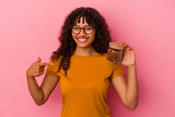 Giovane Donna Razza Mista Possesso Vaso Mandorle Isolato Sfondo Rosa — Foto Stock