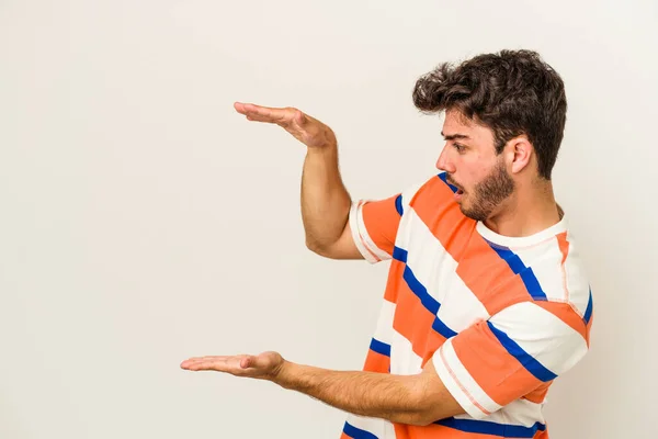 Joven Hombre Caucásico Aislado Sobre Fondo Blanco Sorprendido Sorprendido Sosteniendo —  Fotos de Stock