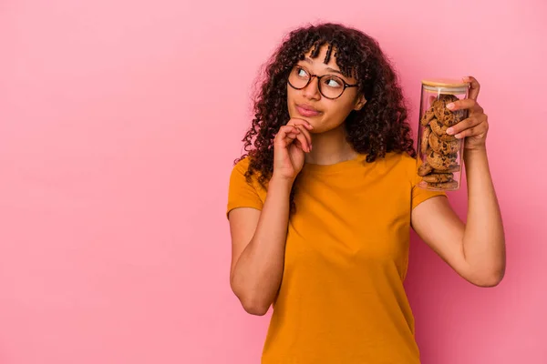 Jovem Mulher Raça Mista Segurando Frasco Biscoitos Isolado Fundo Rosa — Fotografia de Stock