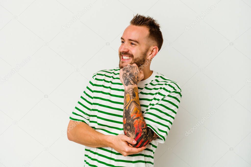 Young tattooed caucasian man isolated on white background smiling happy and confident, touching chin with hand.