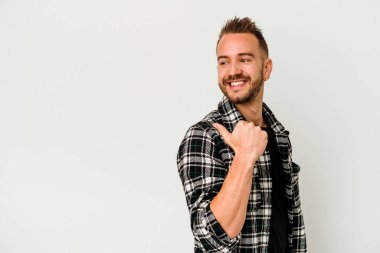 Genç, dövmeli, beyaz arka planda izole edilmiş beyaz bir adam başparmak uzakta, gülüyor ve kaygısız..