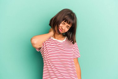 Genç melez kadın, mavi üzerine izole edilmiş. Stres yüzünden boynu ağrıyor. Masaj yapıyor ve elle dokunuyor..