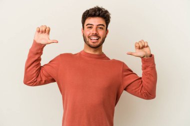 Beyaz arka planda izole edilmiş genç beyaz adam gururlu ve kendinden emin hissediyor, örnek olarak..