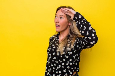 Genç Avustralyalı kadın yalnız başına uzaklara bakıyor ve elini alnına koyuyor..