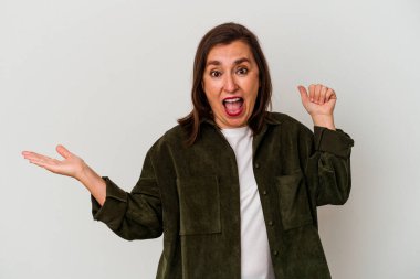 Beyaz arka planda izole edilmiş orta yaşlı beyaz kadın avuç içinde fotokopi alanı tutuyor, el üstünde tutuyor. Şaşırmış ve mutlu..