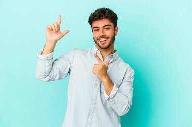 Genç beyaz adam mavi arka planda izole edilmiş dans ediyor ve eğleniyor..