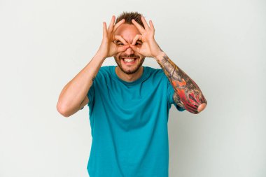 Beyaz arka planda izole edilmiş genç, dövmeli beyaz bir adam heyecanlı..