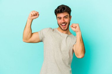 Genç beyaz adam mavi arka planda izole edilmiş dans ediyor ve eğleniyor..