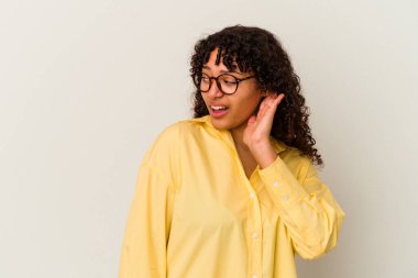 Beyaz arka planda izole edilmiş genç melez kadın bir dedikoduyu dinlemeye çalışıyor..