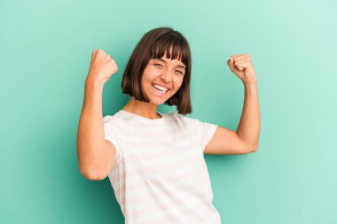 Genç melez kadın mavi neşeyle izole edilmiş kaygısız ve heyecanlı. Zafer konsepti.