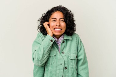 Beyaz arka planda izole edilmiş, elleri kulaklarında genç kıvırcık Latin kadın..