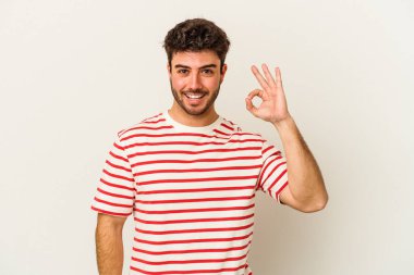 Beyaz arka planda izole edilmiş genç beyaz bir adam neşeli ve kendinden emin..