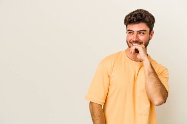 Beyaz arka planda izole edilmiş genç beyaz bir adam rahatlamış bir şeyin fotokopi odasına baktığını düşünüyor..