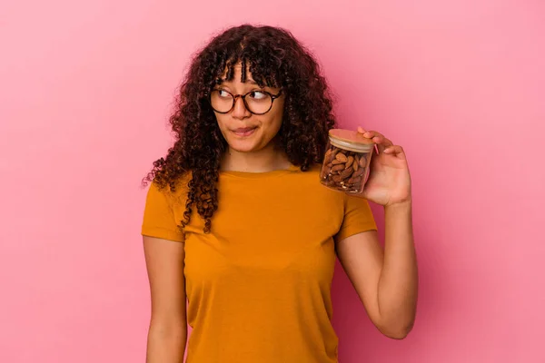 Ung Blandras Kvinna Håller Mandel Burk Isolerad Rosa Bakgrund Förvirrad — Stockfoto