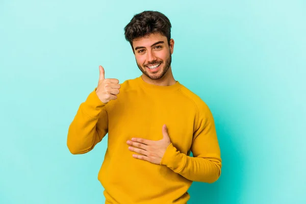 Νεαρός Καυκάσιος Άνδρας Απομονωμένος Μπλε Φόντο Αγγίζει Την Κοιλιά Χαμογελάει — Φωτογραφία Αρχείου