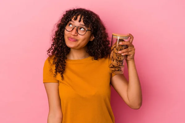 Jovem Mulher Raça Mista Segurando Frasco Biscoitos Isolado Fundo Rosa — Fotografia de Stock