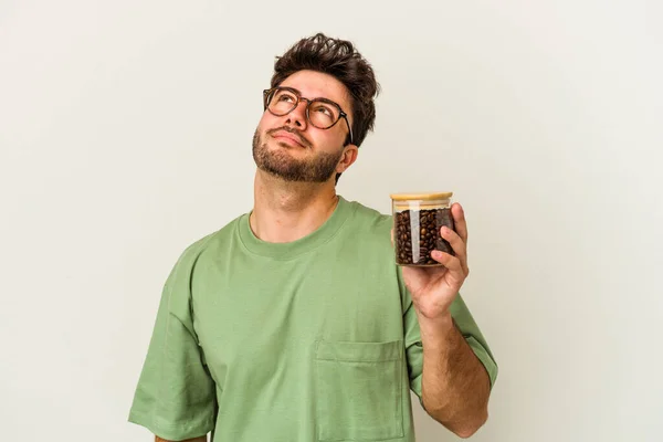 Ung Kaukasisk Man Som Håller Kaffeburk Isolerad Vit Bakgrund Drömmer — Stockfoto