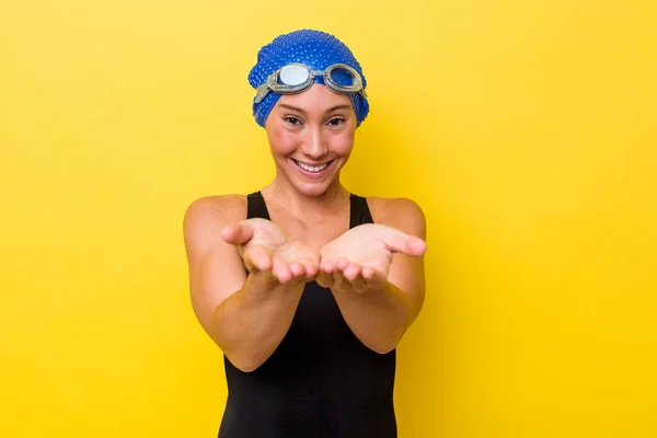 澳大利亚年轻的游泳女子 被隔离在黄色背景下 手持手掌 主动提供相机 — 图库照片