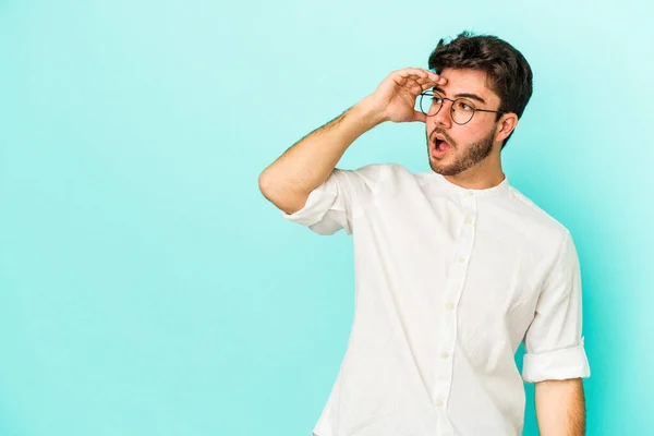 Ung Kaukasisk Man Isolerad Blå Bakgrund Ser Långt Borta Att — Stockfoto