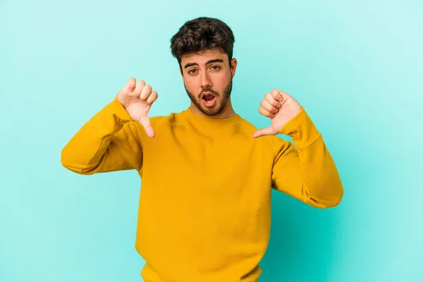 Ung Kaukasisk Man Isolerad Blå Bakgrund Visar Tummen Ner Och — Stockfoto