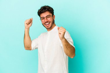 Genç beyaz adam mavi arka planda izole edilmiş dans ediyor ve eğleniyor..