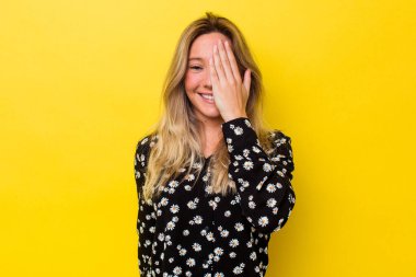 Avustralyalı genç bir kadın izole edilmiş. Yüzünün yarısını avuç içiyle kaplayarak eğleniyor..