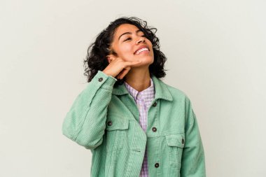 Beyaz arka planda izole edilmiş genç kıvırcık Latin kadın parmaklarıyla bir cep telefonu hareketi gösteriyor..