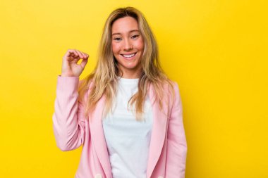 Avustralyalı genç bir kadın bir şeylere gülüyor, elleriyle ağzını kapatıyor..