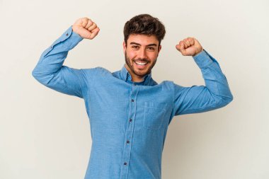 Beyaz arka planda izole genç beyaz adam özel bir günü kutluyor, atlıyor ve enerjiyle kollarını kaldırıyor..