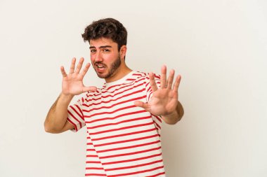 Beyaz arka planda izole edilmiş genç beyaz bir adam tiksinti belirtisi gösteren birini reddediyor..