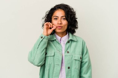 Beyaz arka planda izole edilmiş genç kıvırcık Latin kadın parmakları dudaklarında bir sır saklıyor..