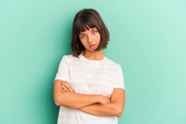 Mavi üzerine izole edilmiş, sıkılmış, yorgun ve dinlenmeye ihtiyacı olan genç melez bir kadın..