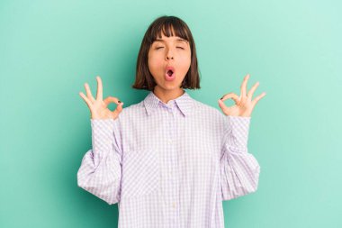 Genç melez kadın mavi renkte izole edilmiş yoğun çalışma gününden sonra yoga yapıyor..