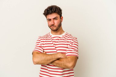 Beyaz arka planda izole edilmiş genç beyaz bir adam şüpheli, belirsiz, seni muayene ediyor..