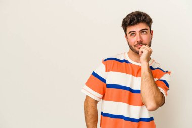 Beyaz arka planda izole edilmiş genç beyaz bir adam rahatlamış bir şeyin fotokopi odasına baktığını düşünüyor..