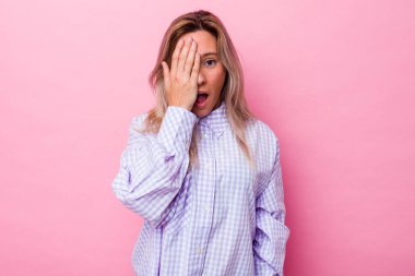 Avustralyalı genç bir kadın izole edilmiş. Yüzünün yarısını avuç içiyle kaplayarak eğleniyor..