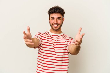 Beyaz arka planda izole edilmiş genç beyaz adam kameraya sarıldığı için kendinden emin hissediyor..