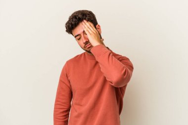 Beyaz arka planda izole edilmiş genç beyaz bir adam bir şeyi unutuyor. Alnına avuç içi ve gözlerini kapayarak vuruyor..