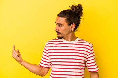 Sarı arka planda izole edilmiş uzun saçlı beyaz bir adam seni işaret ediyor. Sanki davet ediliyormuş gibi..