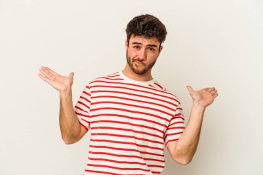 Beyaz arka planda izole edilmiş genç beyaz bir adam. Kafası karışmış ve omuz silkiyor. Kopya alanını tutmak için..