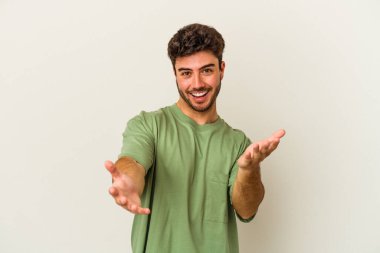 Beyaz arka planda izole edilmiş genç beyaz adam kameraya sarıldığı için kendinden emin hissediyor..