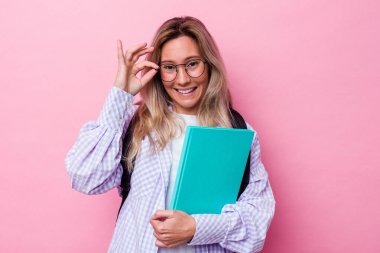 Avustralyalı genç bir öğrenci pembe arka planda izole edilmiş. Heyecanlı..