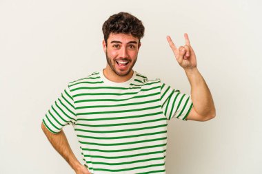 Beyaz arka planda izole edilmiş genç beyaz bir adam boynuzlarını devrim konsepti olarak gösteriyor..