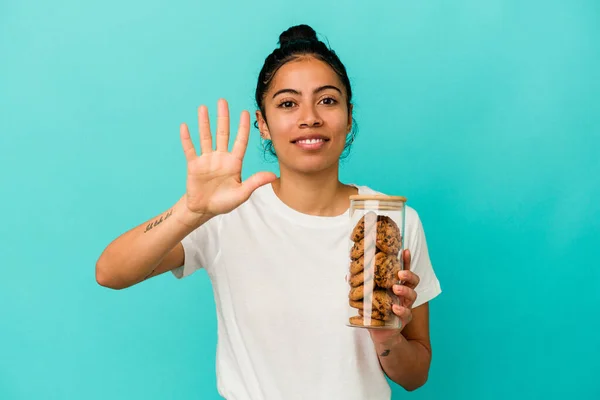 Ung Latinamerikansk Kvinna Håller Kakburk Isolerad Blå Bakgrund Ler Glad — Stockfoto