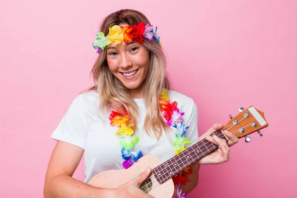 年轻的Hawaiian女人扮演一个被粉色背景隔离的Ukulele — 图库照片