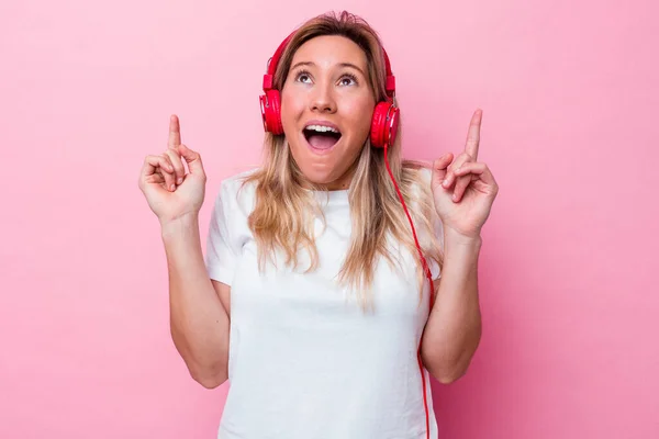 Νεαρή Αυστραλή Γυναίκα Ακούει Μουσική Απομονωμένη Ροζ Φόντο Δείχνοντας Ανάποδα — Φωτογραφία Αρχείου