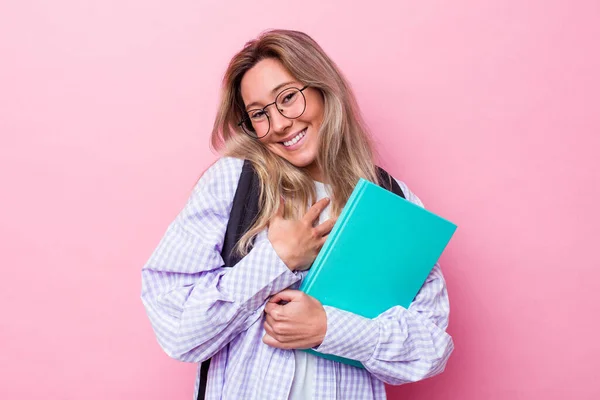 年轻的澳大利亚女学生被隔离在粉红的背景下 大声笑着把手放在胸前 — 图库照片